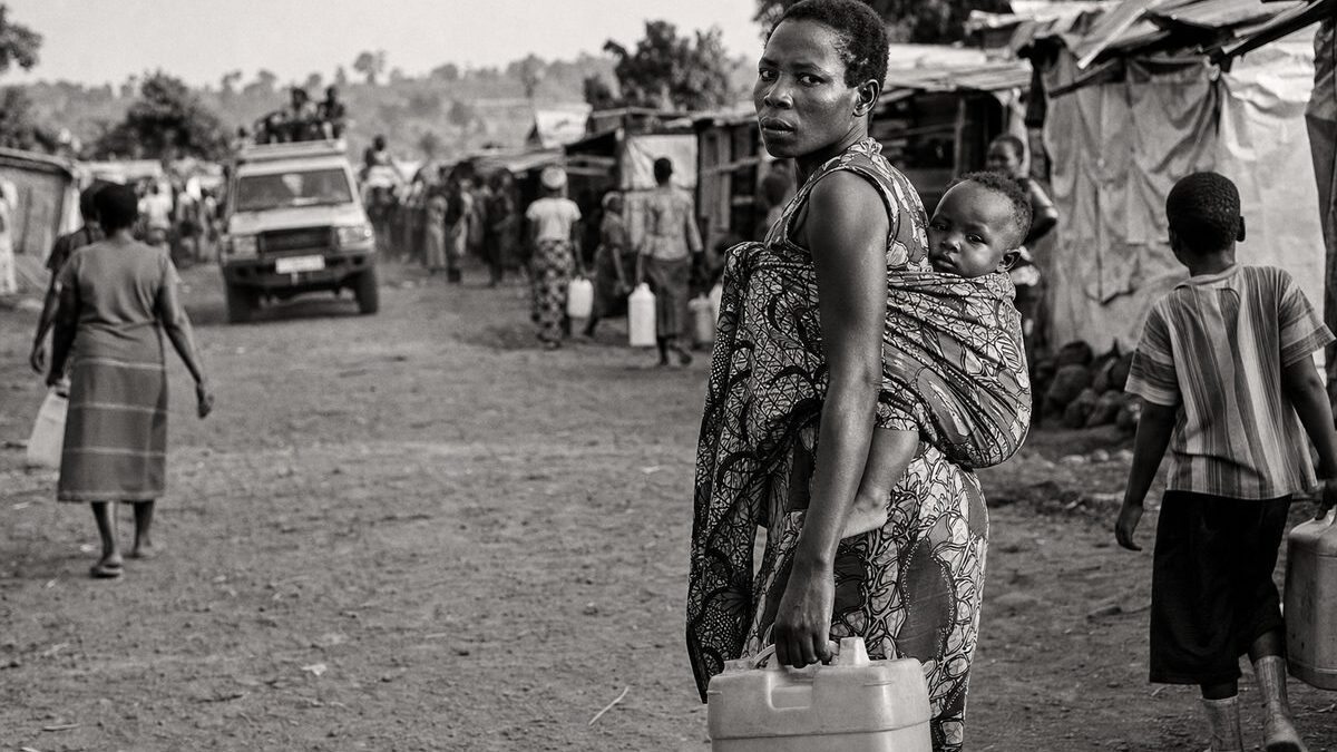 Displaced-persons settlement of tarpaulin shelters on a dirt road in eastern Congo, people carrying water (AI-generated image)
