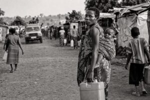 Displaced-persons settlement of tarpaulin shelters on a dirt road in eastern Congo, people carrying water (AI-generated image)