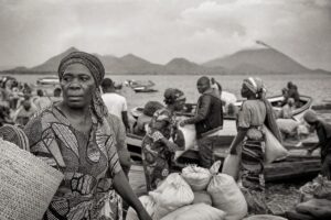 Cross-border lakeshore market with wooden boats and traders, hazy volcanic hills across the water (AI-generated image)