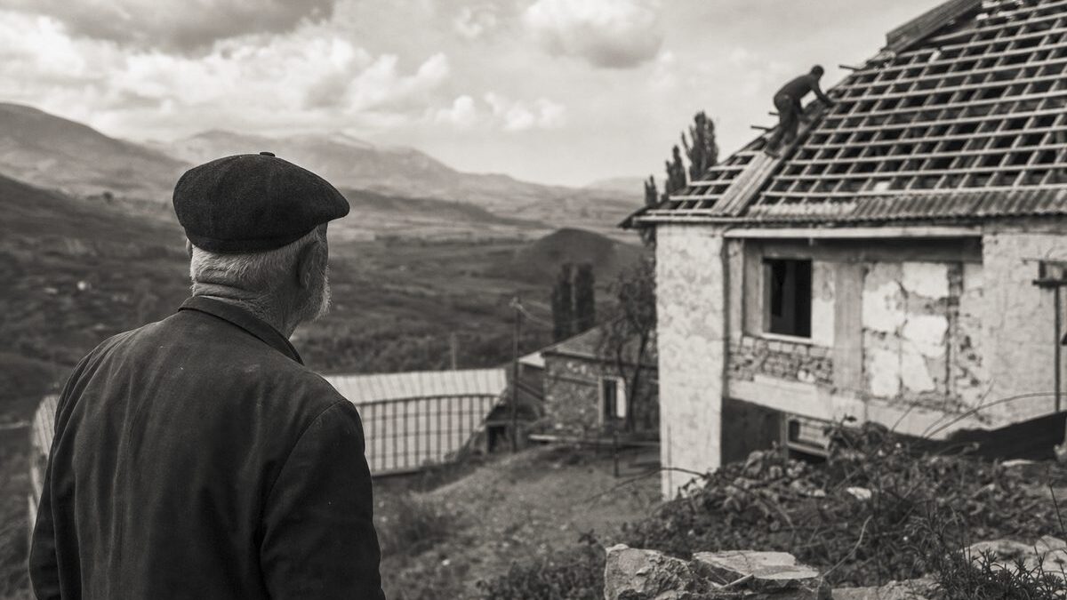Hillside village in Georgia, a house roof under repair, an elderly man looking across the valley (AI-generated image)
